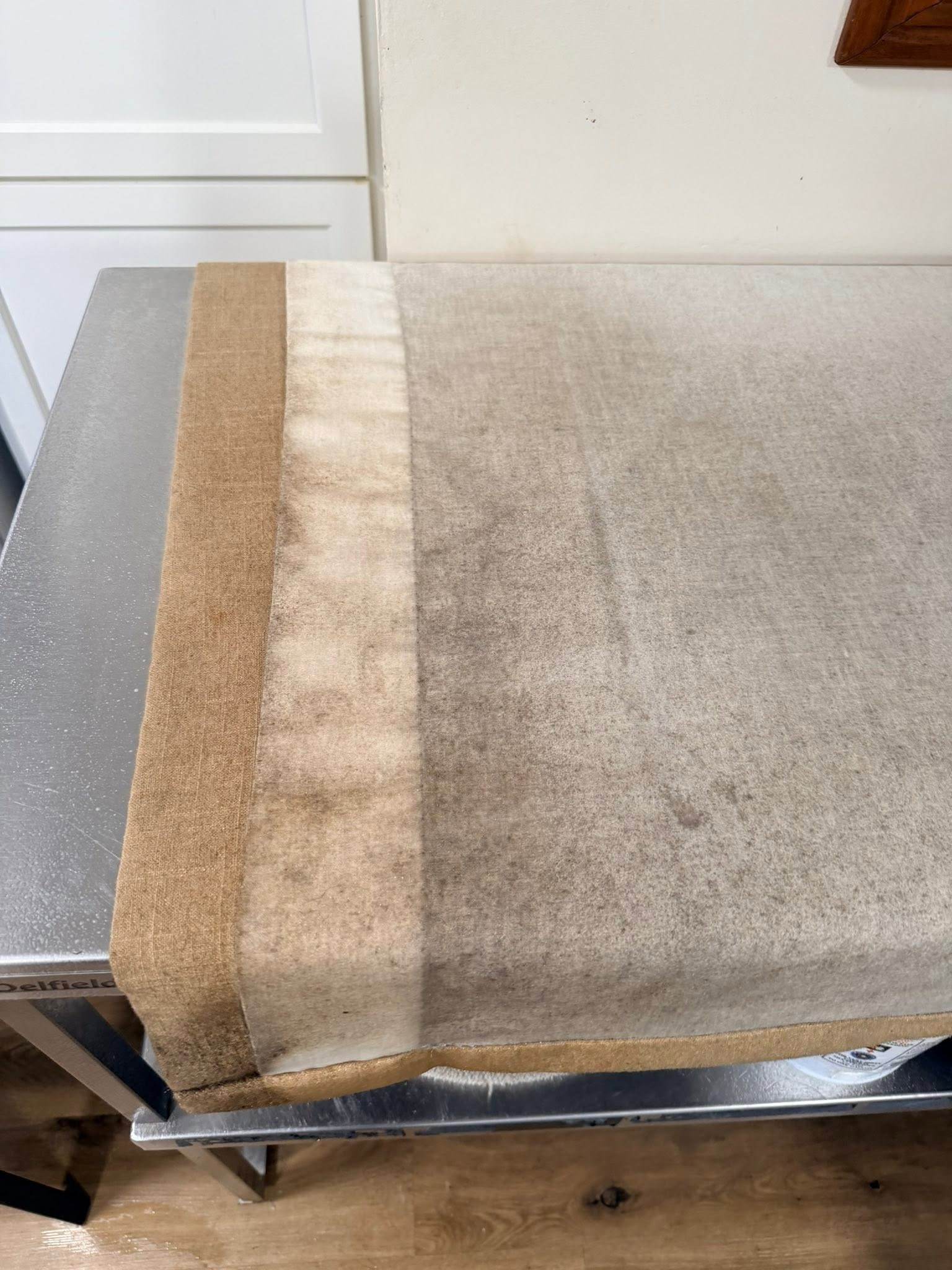 Lined drapery panel before cleaning with dull gray soil